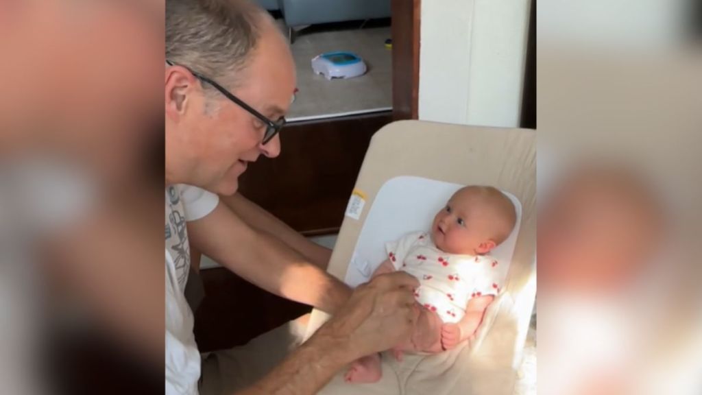 A deaf grandpa uses sign language to communicate with a baby.