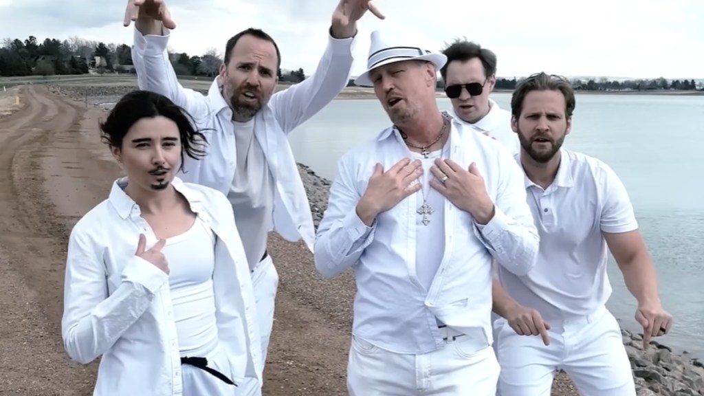 Five Denver Water employees pose like a boyband on a beach. They're all wearing white. The one woman has a drawn-on beard.