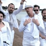 Five Denver Water employees pose like a boyband on a beach. They're all wearing white. The one woman has a drawn-on beard.