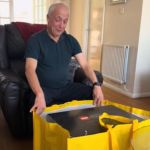 A dad is excited to open a yellow Lego bag.