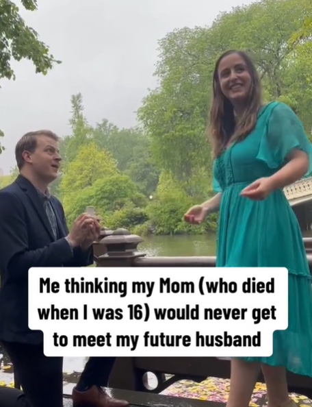 A man proposing to a woman in a green dress.