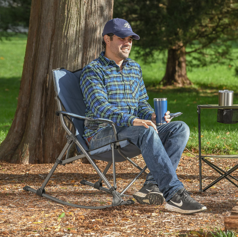 A man sitting outside in a foldable rocking chair.
