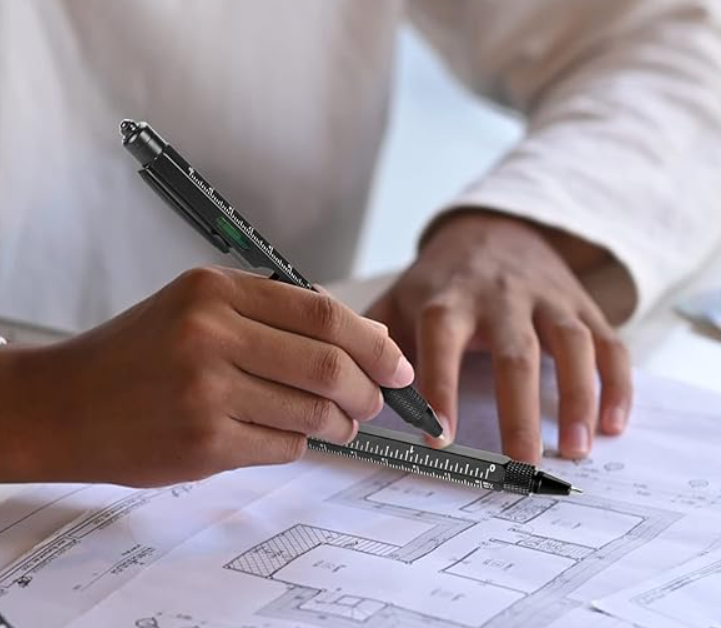 A man using a pen with a ruler along the side.