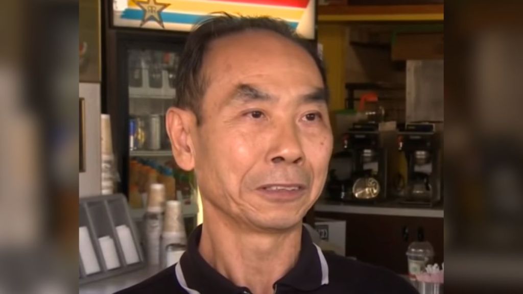 A close up of an elderly donut shop owner.