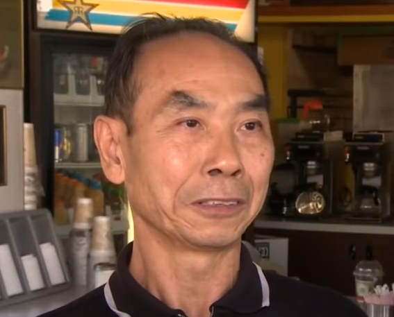 A close up of an elderly donut shop owner.