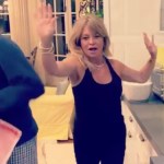 Goldie Hawn raises her hands in the air as she dances through her kitchen.