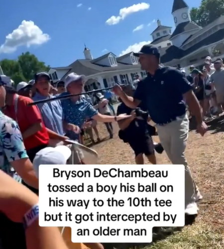 Bryson DeChambeau points his golf club at someone in the crowd.