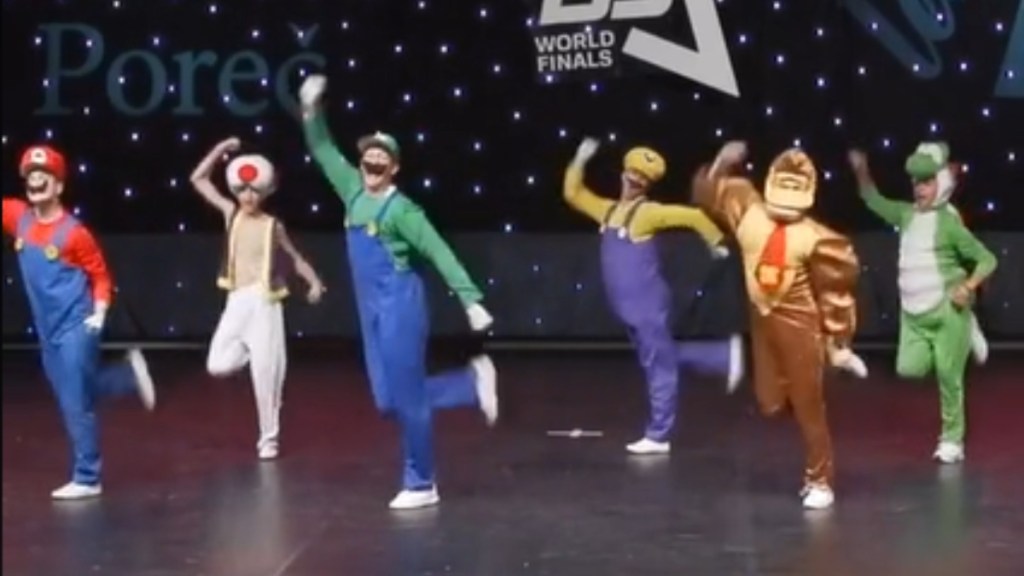 A dance group performs while dressed as Mario characters: Mario, Toad, Luigi, Wario, Donkey Kong, and Yoshi