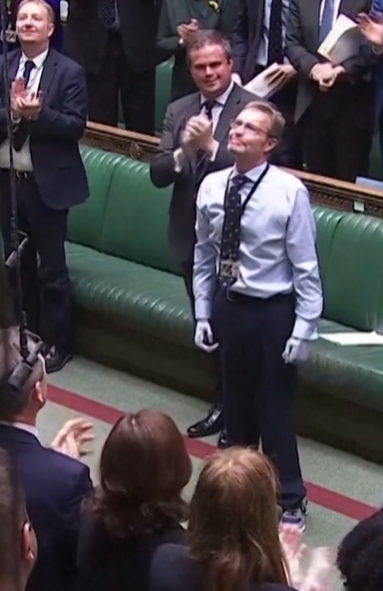 A politican receives applause while returning to work with prosthetic hands and feet.