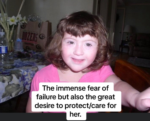 A little girl with brown hair and a pink shirt smiling.