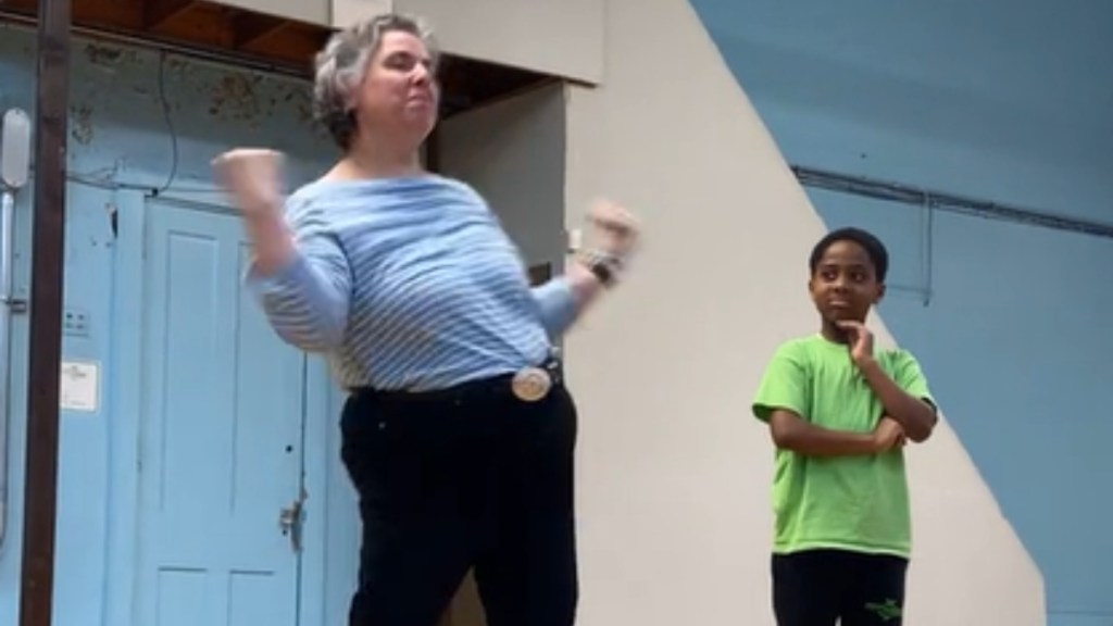 A woman dances as a young boy watches on in a jokingly judging way.