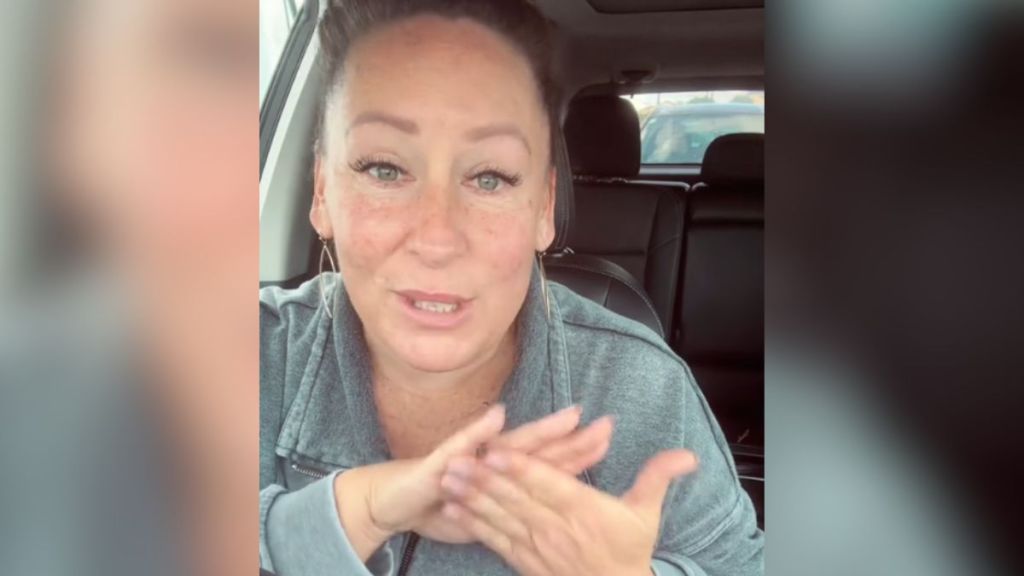 A woman tells a story into the camera while sitting in her car.