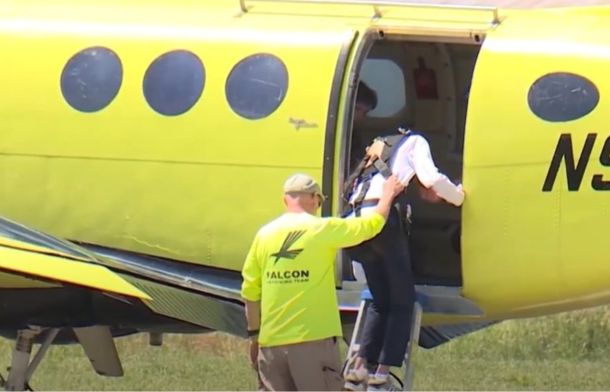 Image shows Mark Johnson getting into an airplane with his jumpmaster.