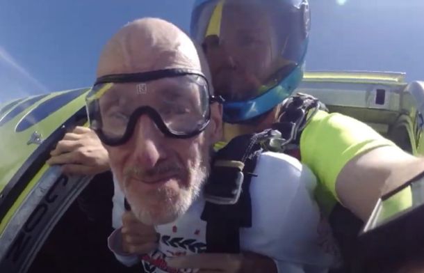 Image shows a tandem skydiving jump team preparing to exit the airplane.
