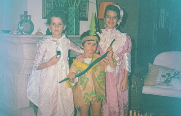 Image shows two young girls and a young boy dressed in costumes from around the mid 1980s.