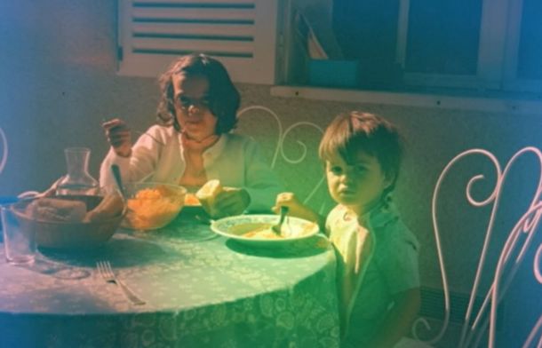 Image shows two children sitting in a cafe eating from film found in a flea market camera.