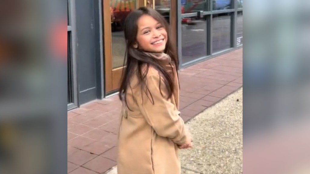 A little girl looks backs, smiling wide