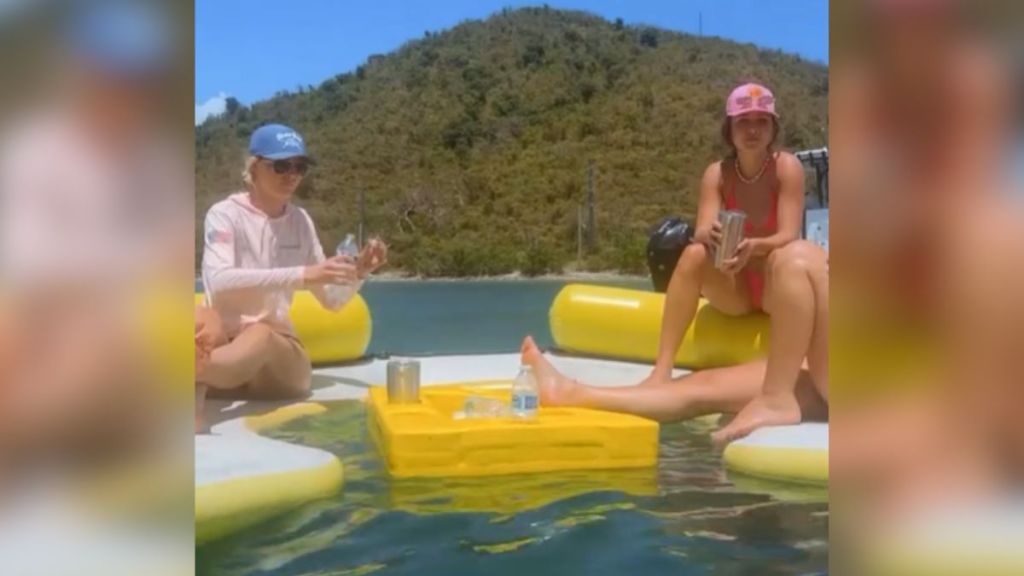 Patrons on floatation devices at a swim up bar.