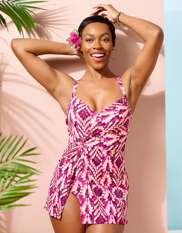 A woman wearing a pink and white swim dress.