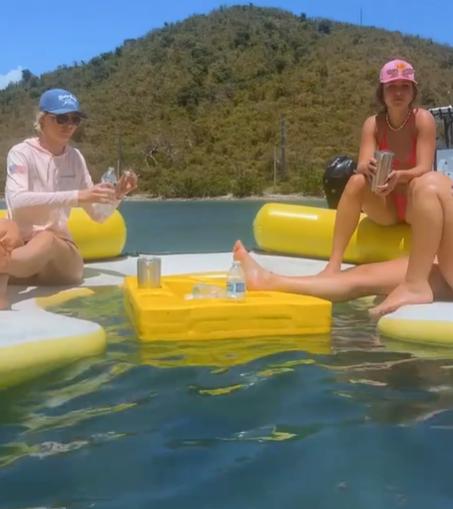 Patrons on floatation devices at a swim up bar.