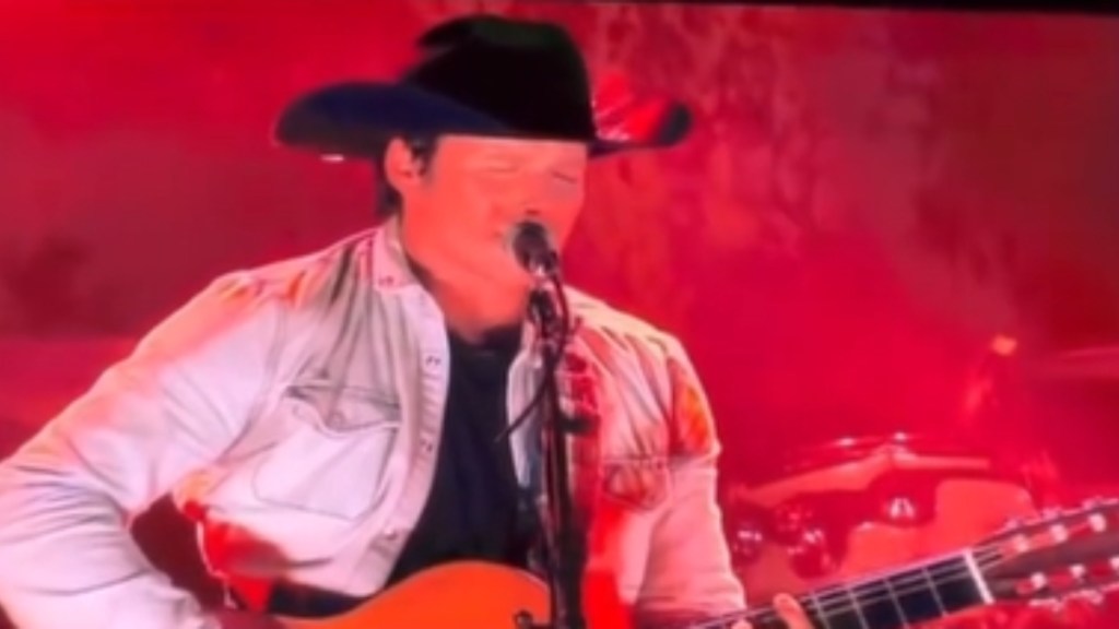 Willie Nelson's son, Lukas, closes his eyes as he sings into a mic and plays guitar