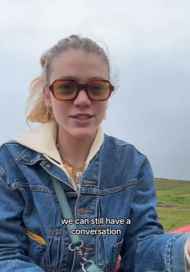 A young woman wearing sunglasses outdoors.