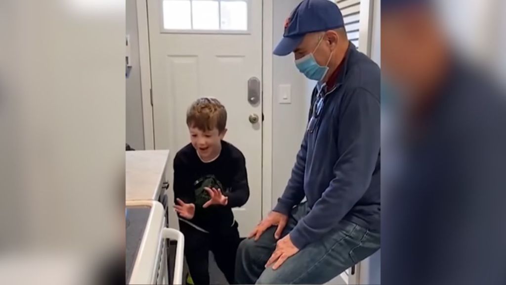 A boy tries to open a drawer with magic while an adult watches.
