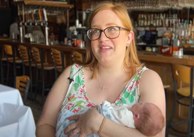A mom holding her baby in the restaurant where she was born.