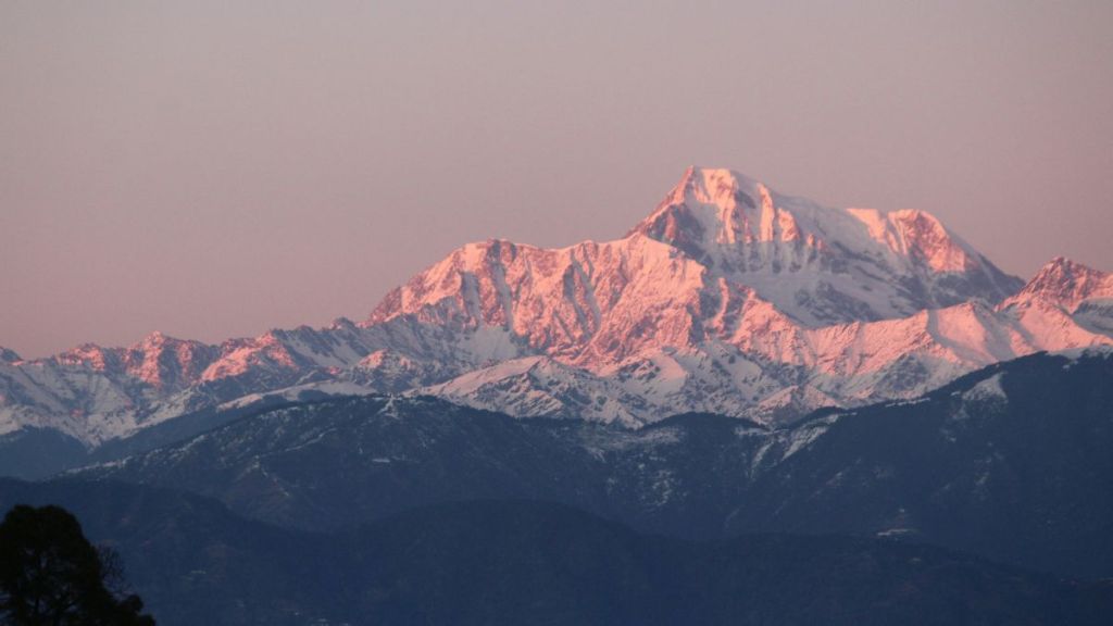 A snowy mountain peak in soft lighting.