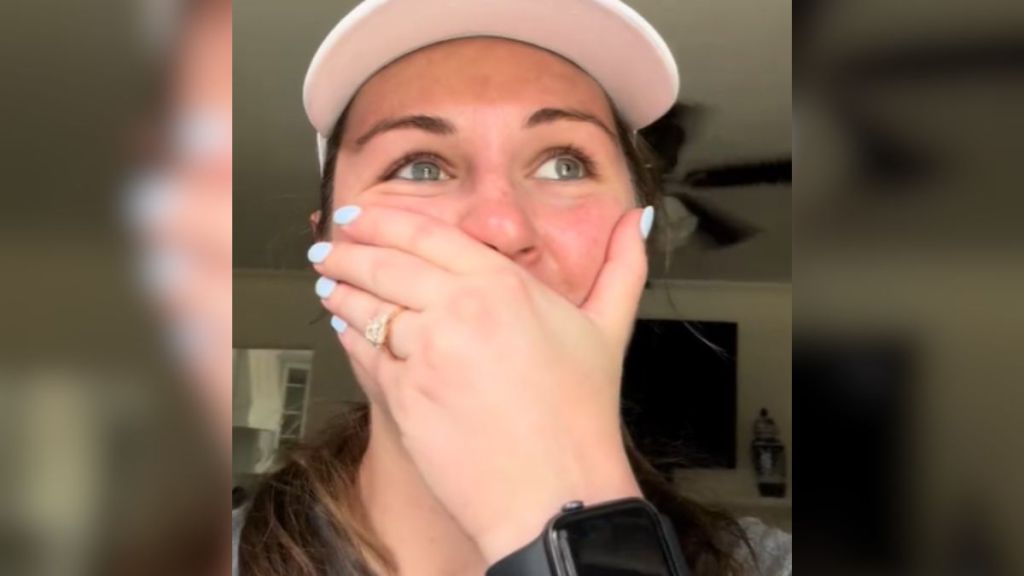 An emotional woman covering her mouth with her hand.