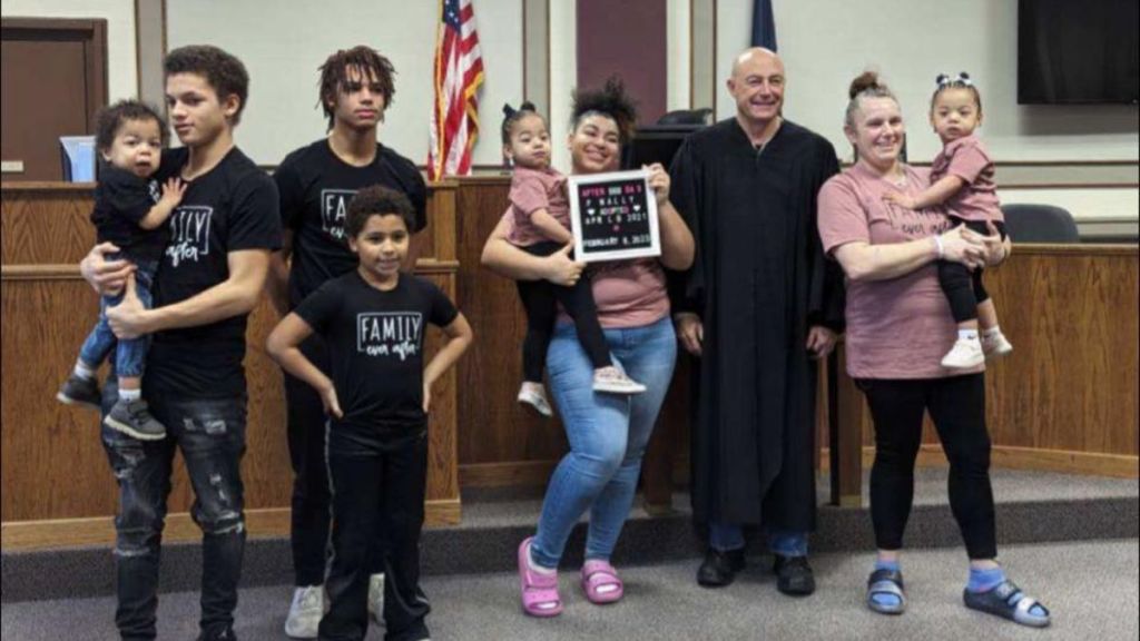 A woman poses with her sons, the teen mom she adopted, and her new triplet grandkids.