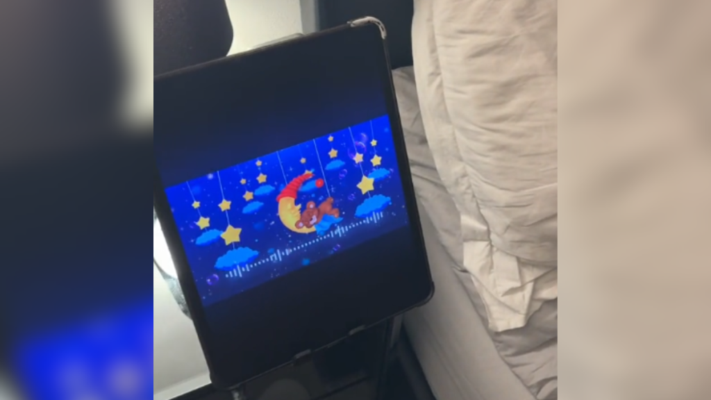 an electronic device playing a lullaby meant to help put the toddler to sleep.