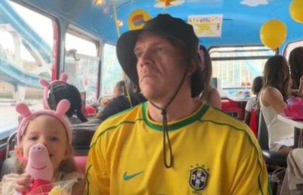 Image shows a man scowling during a Peppa Pig-themed birthday party bus tour. The kids were happy, though.