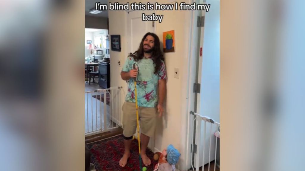 A man with long hair standing next to his baby daughter.