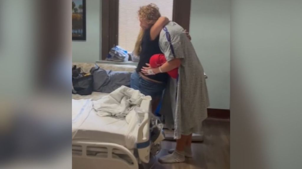 A kidney donor hugging the patient's wife at the hospital.