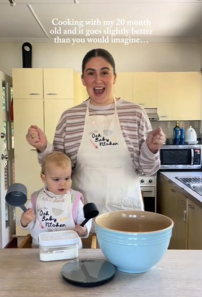 A mom and her toddler baking together in the kitchen.