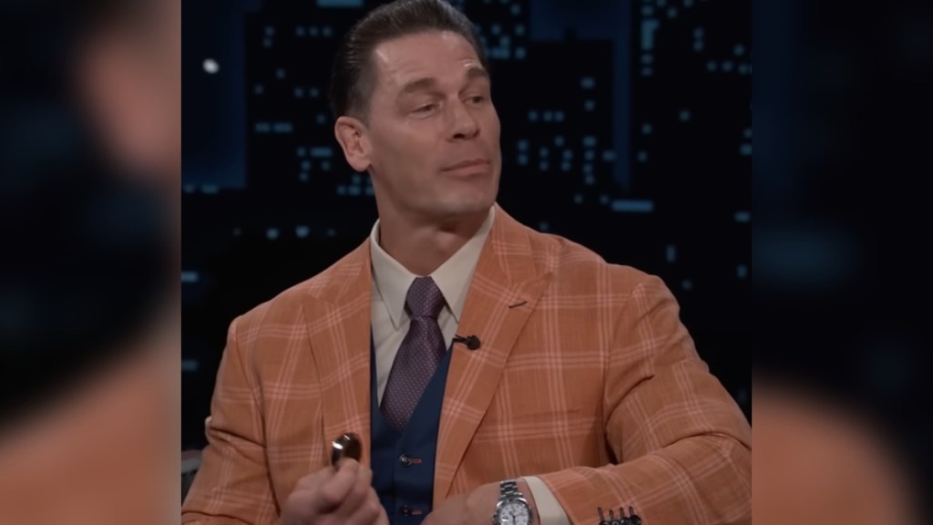 John Cena holds a pocket watch as he talks on a talk show