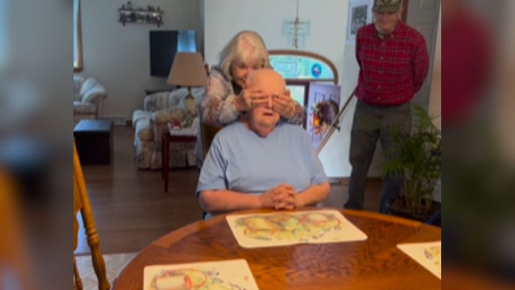 An elderly woman covering another elderly woman's eyes.