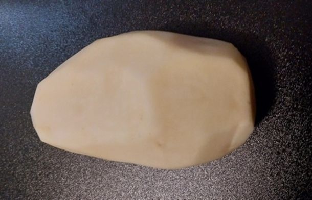 Image shows a raw potato used to see if the Tesla Cybertruck really does look like "a ba-tatoe peeled wif a knife."