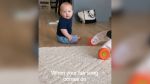 A baby sitting on the floor and looking at the camera.