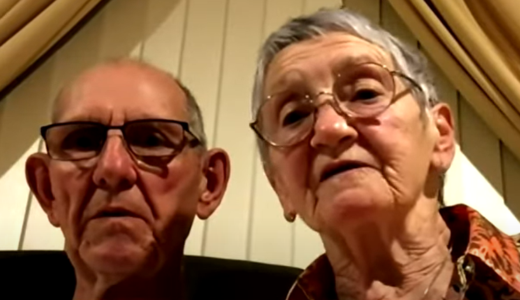 An elderly couple looking into the camera.