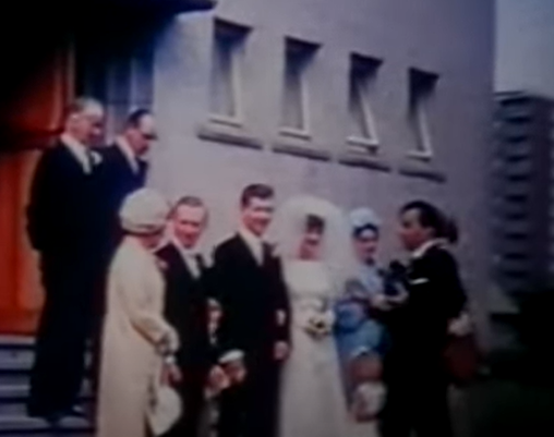 A still from a vintage wedding video taken outside the church.
