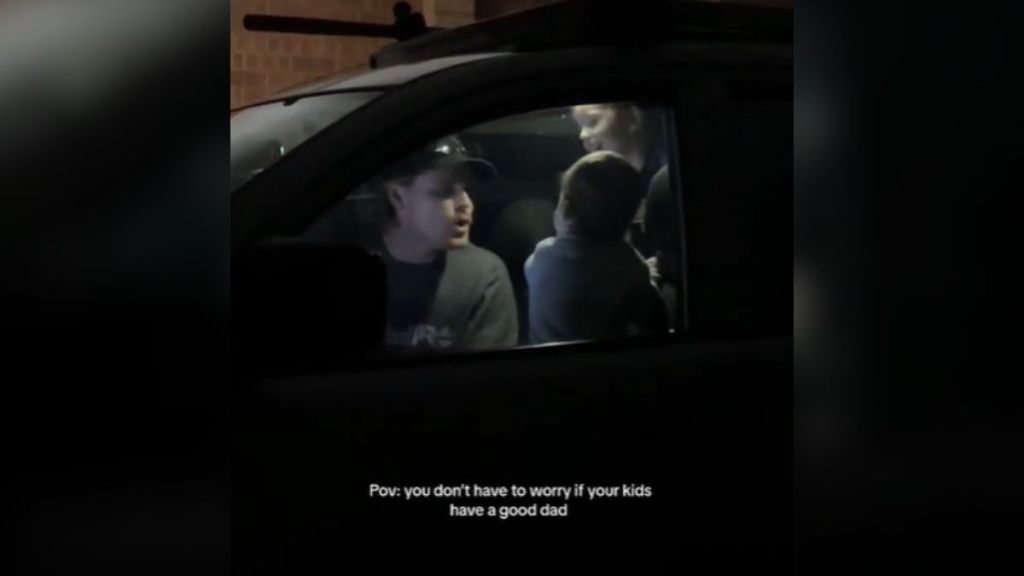 A dad and his kids dancing inside a car.