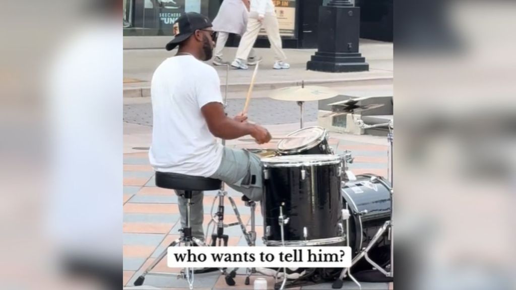 A street musician playing the drums in public.