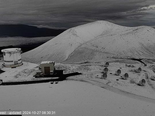 Aerial view of Mauna Kea in Hawaii. Snow covers the peaks and the surrounding ground