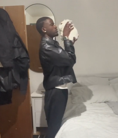 A man holding a white rabbit up to his face.