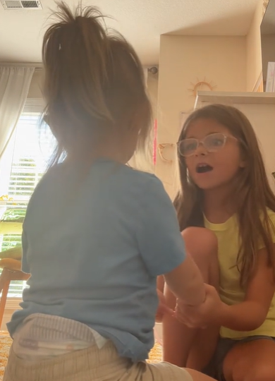 A little girl talking to her younger sister.