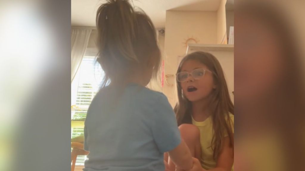 A little girl talking to her younger sister.