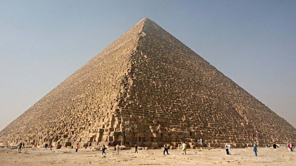 View of the great pyramid of Giza with people standing around at the base.