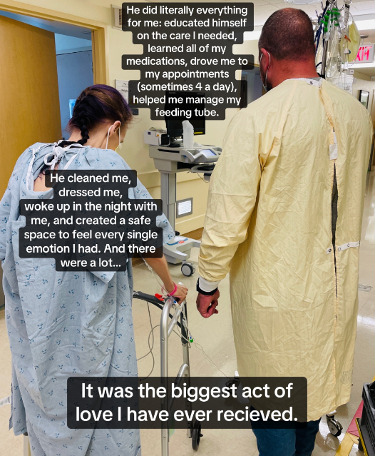 A woman in a hospital gown using a walker while a man stands next to her.